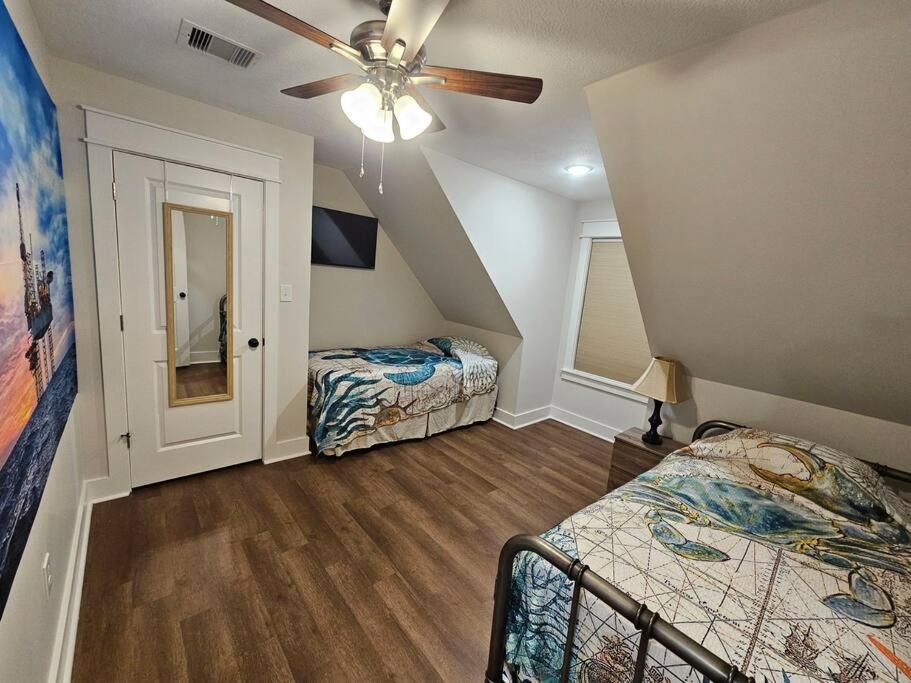 een slaapkamer met 2 bedden en een plafondventilator bij Louisiana 5BR Luxury Pool Retreat in Lake Charles