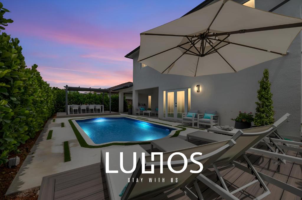 una tapa de revista para una villa con piscina y sombrilla en Glamour Villa - 5BR, Heated Pool, Game Haven L23, en Miami