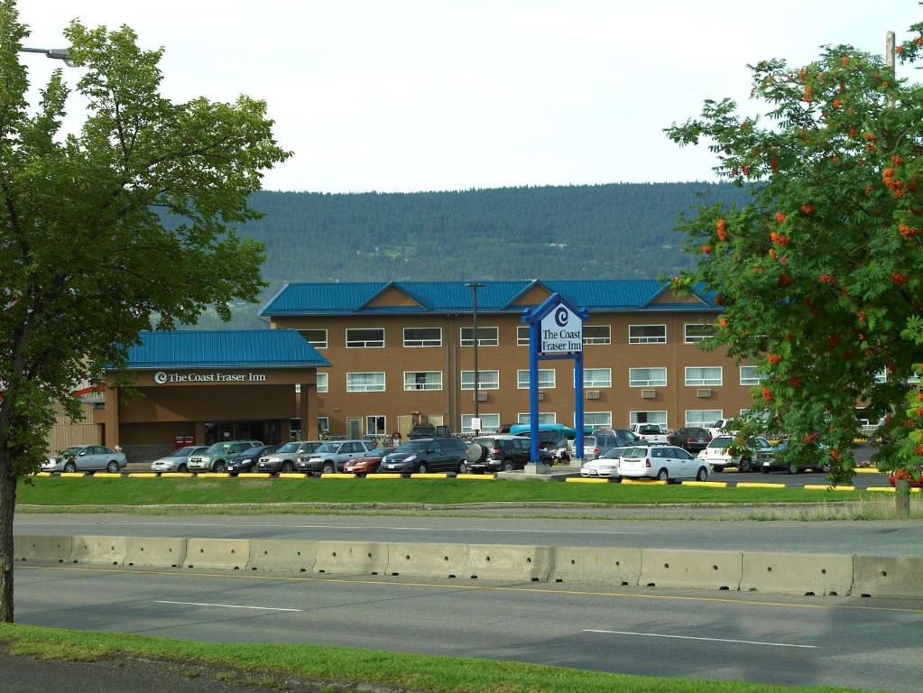 duży budynek z samochodami zaparkowanymi na parkingu w obiekcie Coast Fraser Inn w mieście Williams Lake