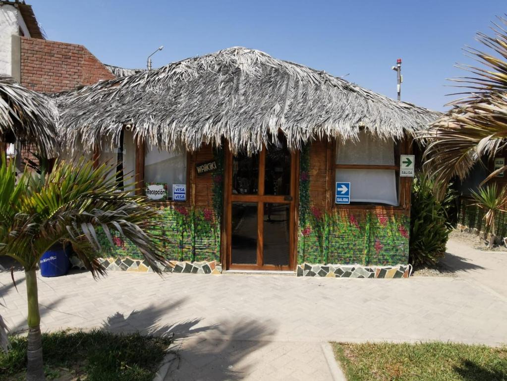 a building with a straw roof with a door at Bora Bora Bungalows in Los Órganos