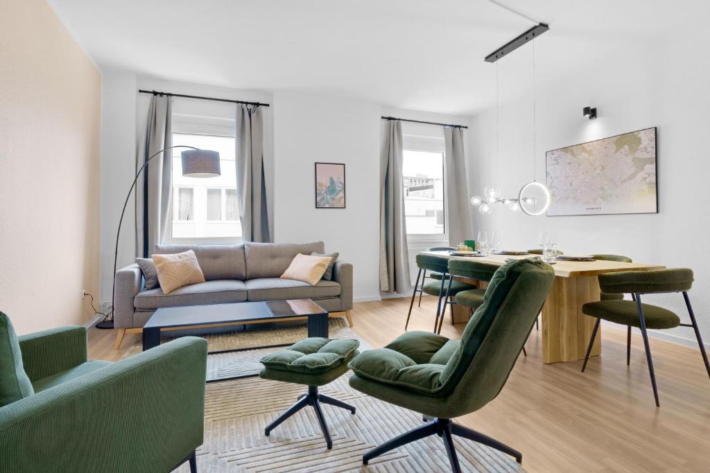 OLIVE Apartments - 86m2 - Kingsize - Free Parking في هانوفر: غرفة معيشة مع أريكة وطاولة وكراسي