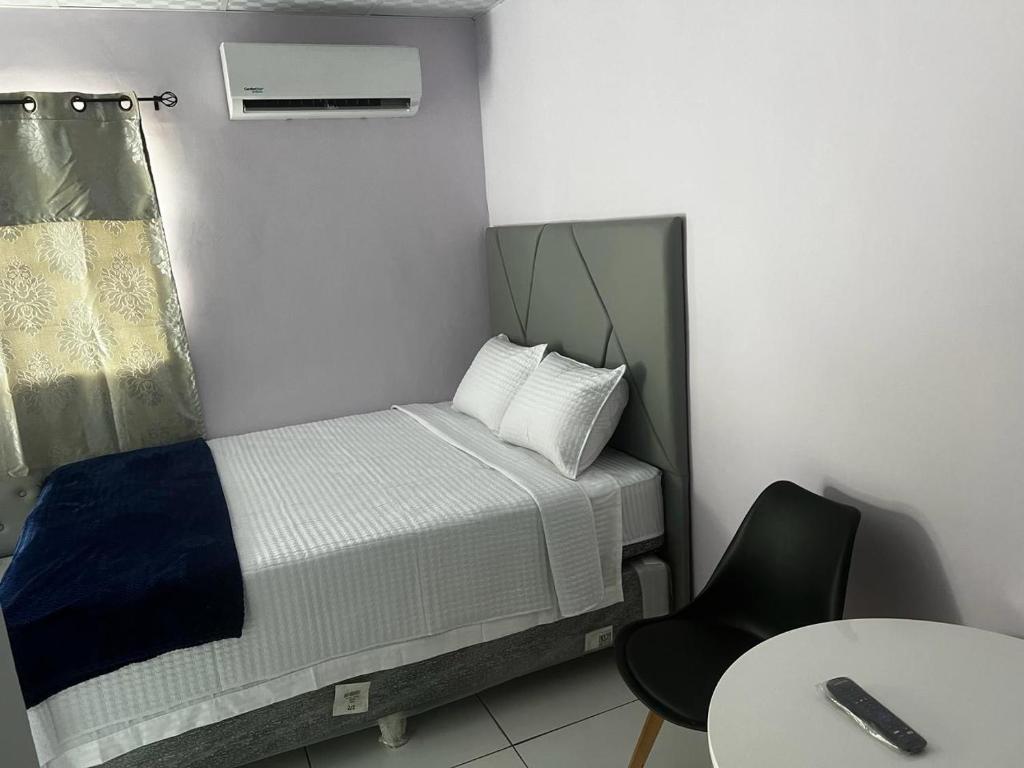 a small bedroom with a bed and a chair at Casa monte sion in Nueva San Salvador