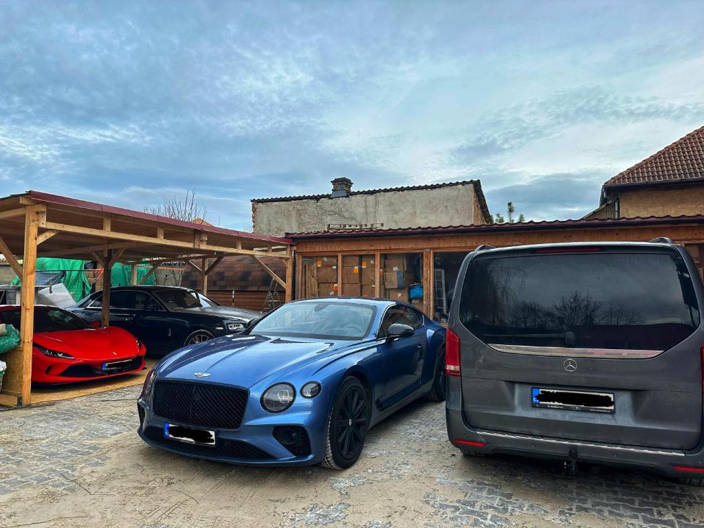 a blue car parked in front of a garage at 布拉格城堡公寓 in Rudná
