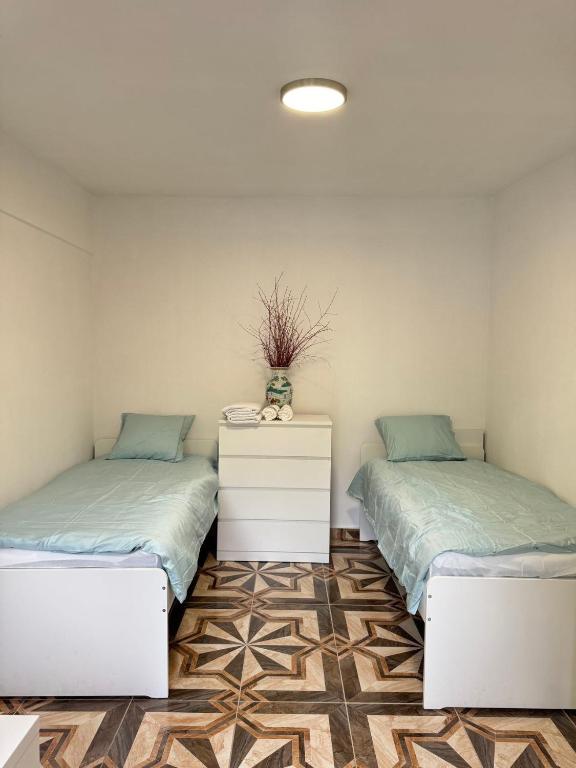 two beds sitting next to each other in a room at 布拉格城堡公寓 in Rudná