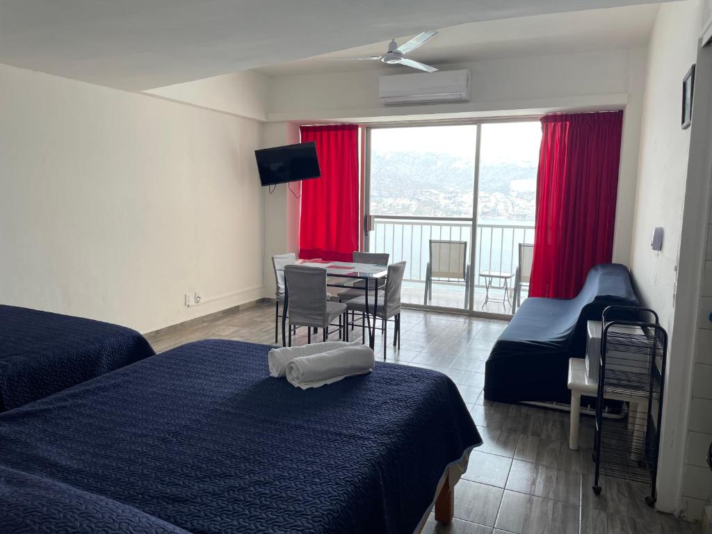 a hotel room with two beds and a table with chairs at Hermosa Suite Torres Gemelas in Acapulco