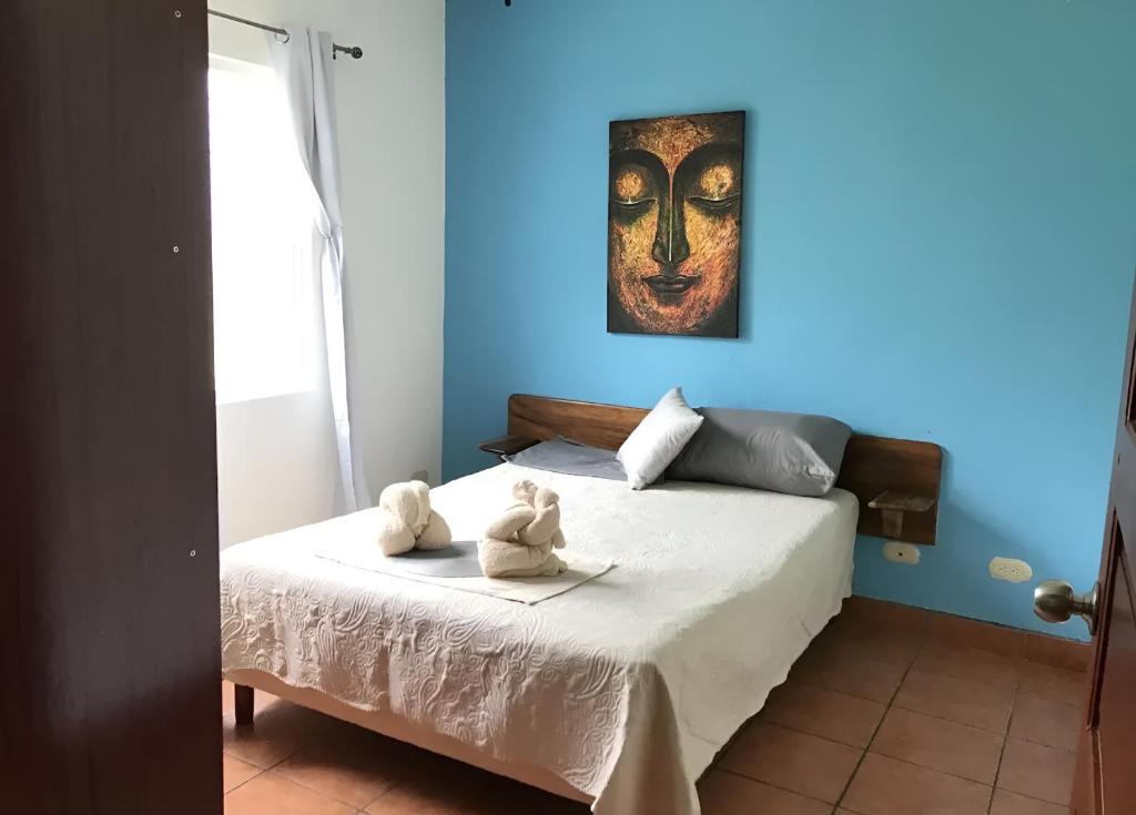 a bedroom with a bed with two stuffed animals on it at Bolimar at Playa Hermosa, Guanacaste in Playa Hermosa