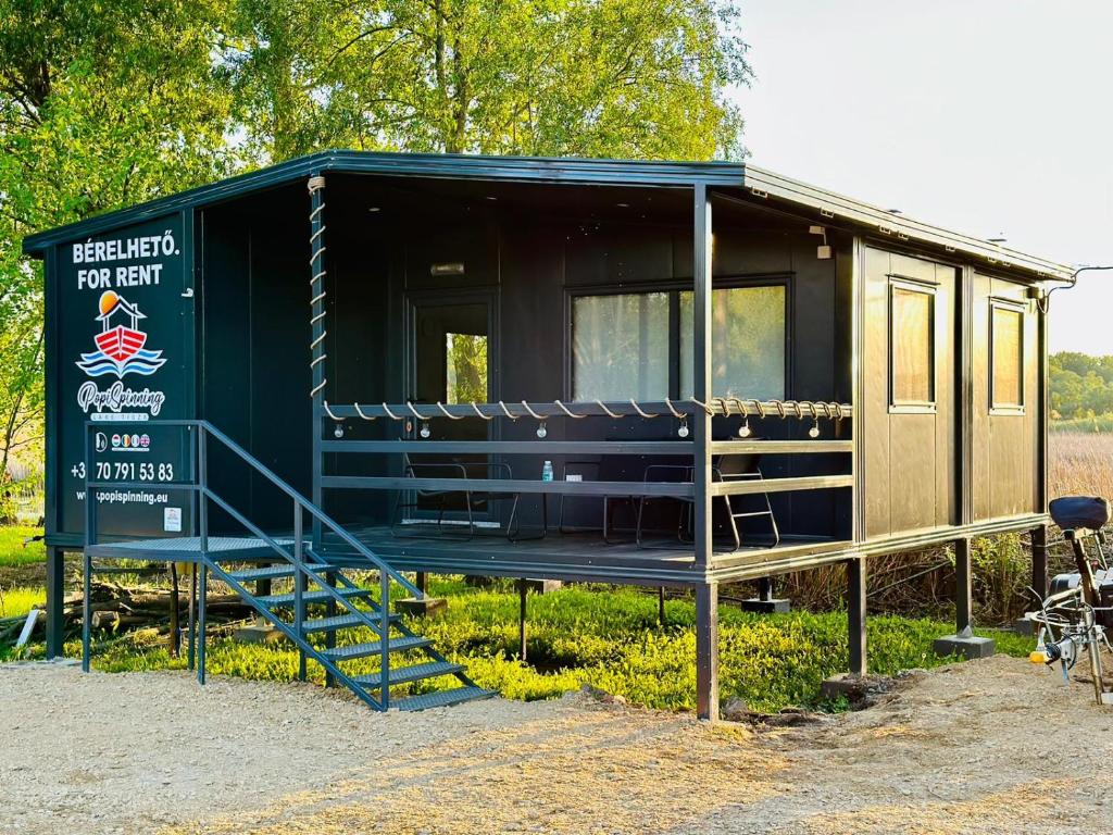 una casita verde en exposición en un campo en Popi Spinning - Lake Tisza, en Tiszafüred