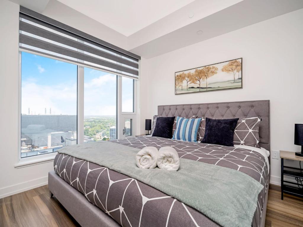 een slaapkamer met een groot bed en een groot raam bij City View 1BR Condo - King Bed & Private Balcony in Kitchener