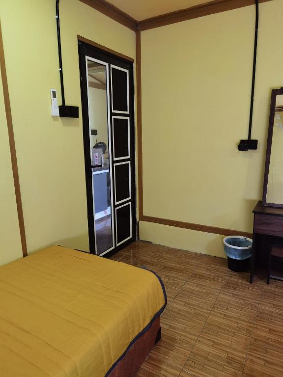 a bedroom with a bed and a mirror and a dresser at Permata Beach Chalet in Kampong Juara