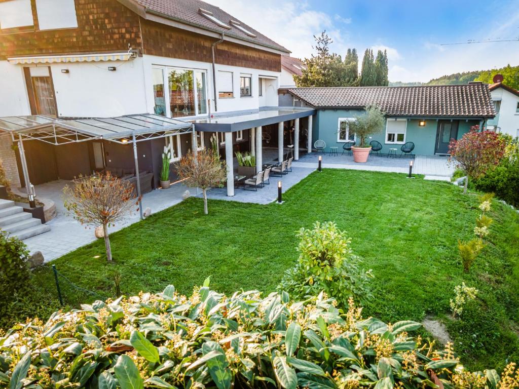 a house with a yard with a large lawn at Ferienwohnung BodenseeSuite in Friedrichshafen in Friedrichshafen