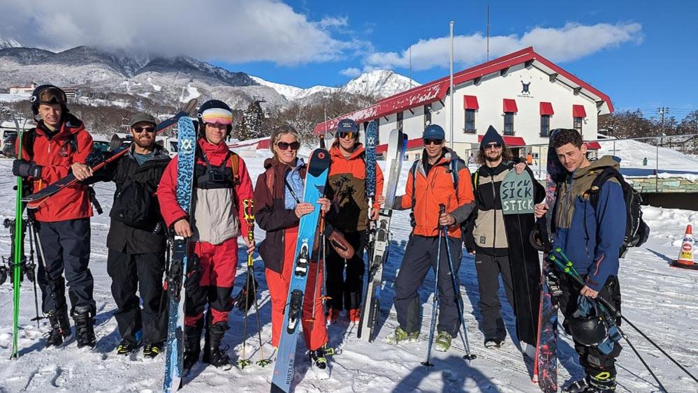 Un gruppo di persone che posano per una foto nella neve di Myoko Mountain Lodge a Myoko