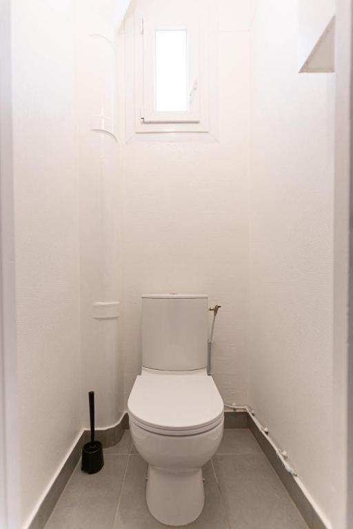 a white toilet in a bathroom with a window at Appartement neuf 3 pièces - Corbeil Essonnes in Corbeil-Essonnes