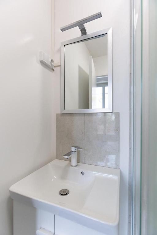 a bathroom with a white sink and a mirror at Appartement neuf 3 pièces - Corbeil Essonnes in Corbeil-Essonnes