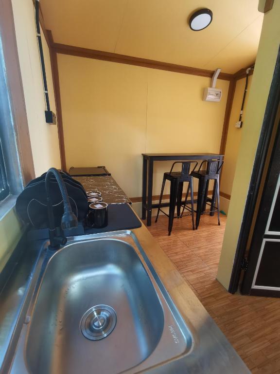 a kitchen with a sink and a table with chairs at Permata Beach Chalet in Kampong Juara