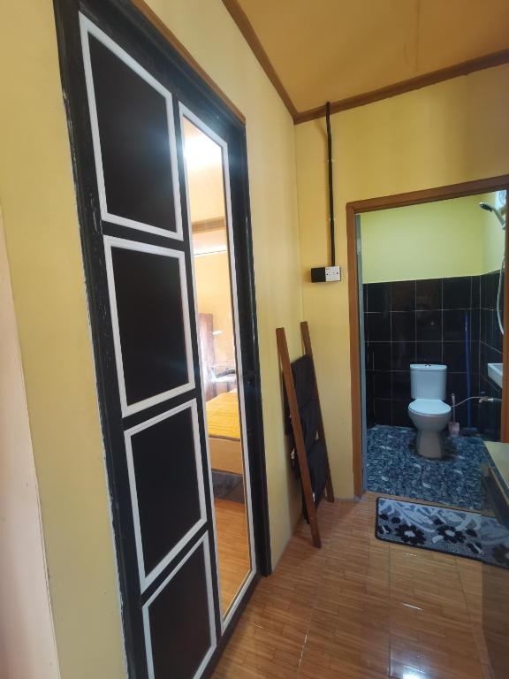 a door leading to a bathroom with a toilet at Permata Beach Chalet in Kampong Juara