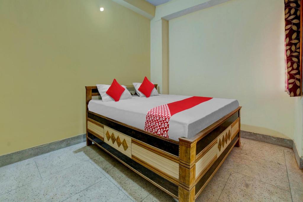 una camera con letto in legno e cuscini rossi di OYO Flagship Hotel Sweet And Soul a Jamshedpur