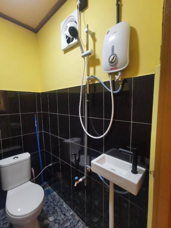 a bathroom with a toilet and a sink at Permata Beach Chalet in Kampong Juara