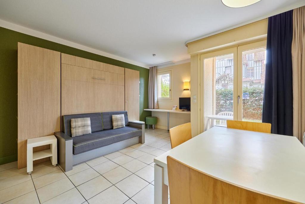 a living room with a couch and a table at Citea Deauville - Tourisme & Vacances mer in Deauville