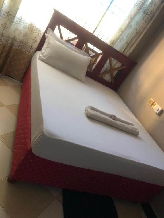 a bed with a pen sitting on top of it at Cam Lodge in Tanga