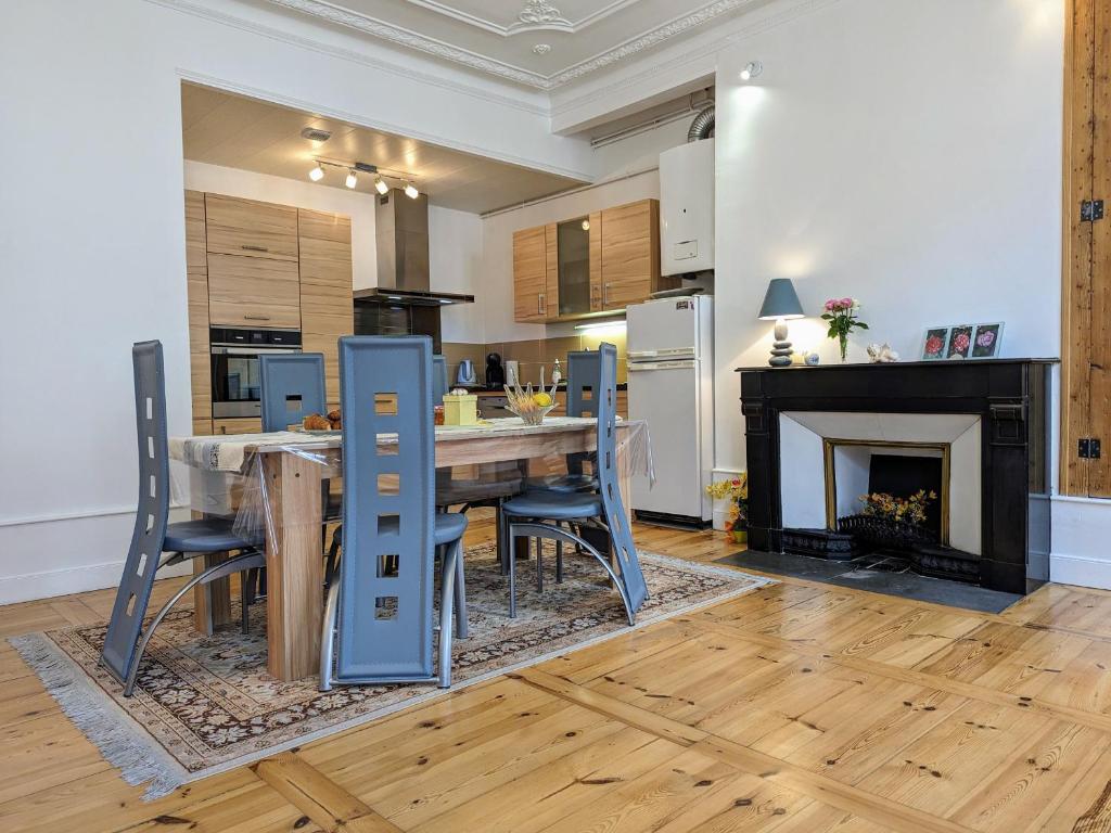 une cuisine avec une table et des chaises ainsi qu'une cheminée dans l'établissement Appartement XIXe siècle - Centre-ville du Puy-en-Velay, 2 chambres, tout confort, proche monuments - FR-1-582-6, au Puy-en-Velay
