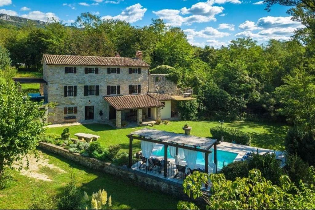 uma vista exterior de uma casa de pedra com uma piscina em Holiday house with a swimming pool Buzet, Central Istria - Sredisnja Istra - 22842 em Buzet