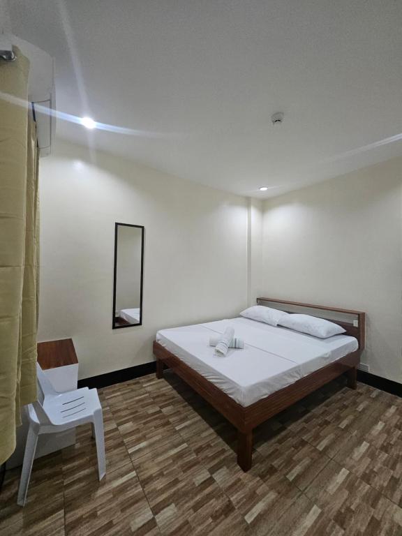 um quarto com uma cama, uma cadeira e um espelho em 4VJ's Apartelle em Pooc