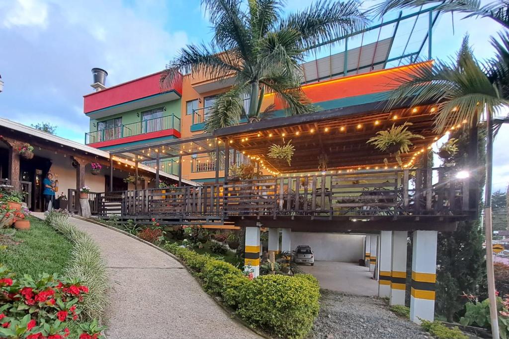um edifício com uma varanda e uma palmeira em Guatapé Country House Hotel em Guatapé