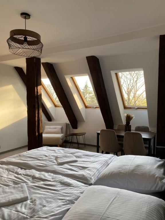 - une chambre avec un lit, une table et des fenêtres dans l'établissement Zamek Nowęcin, à Łeba