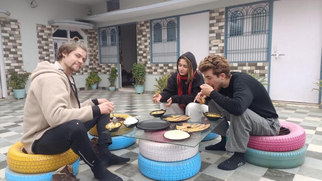 Un gruppo di persone seduti intorno a un tavolo che mangiano cibo di Mohit Paying Guest house a Varanasi