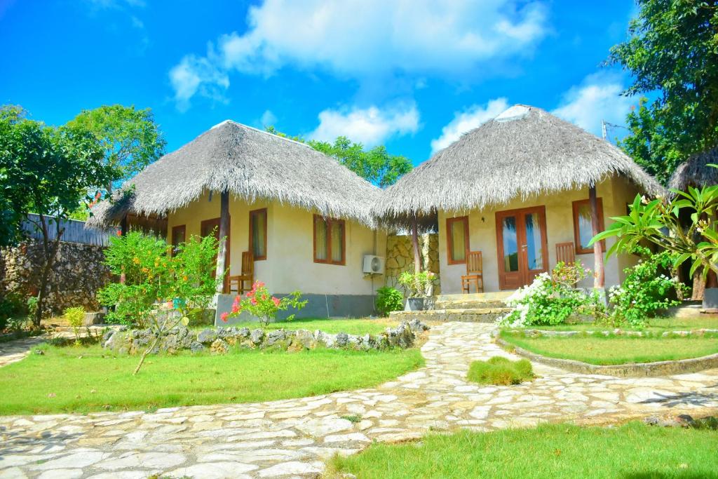 ein Haus mit Grasdach in der Unterkunft Mulia Bungalows in Nembrala