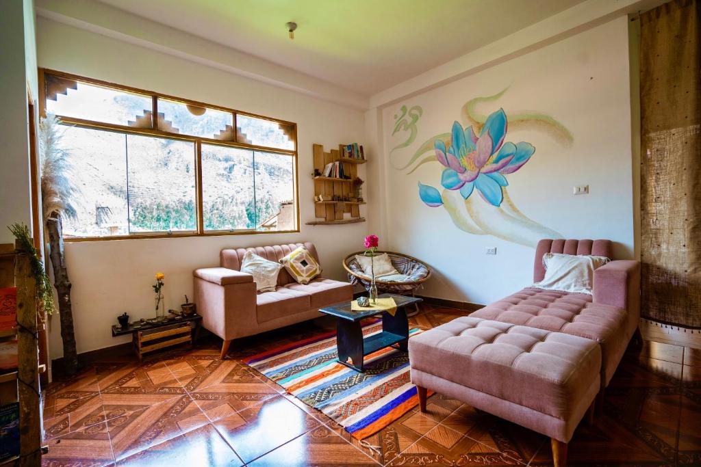 uma sala de estar com dois sofás e uma flor pintada na parede em Blue Lotus Retreat Center em Písac