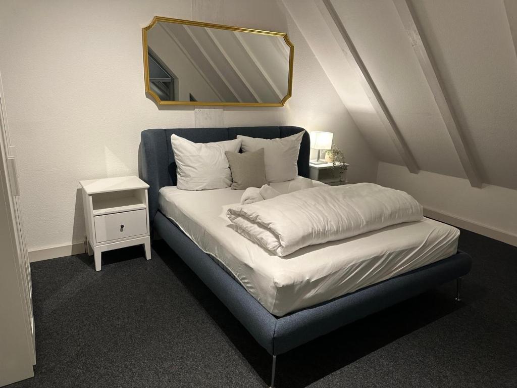 1 dormitorio con 1 cama con espejo. en Zentral gelegenes Premium-Apartment mit viel Tageslicht, en Hamburgo