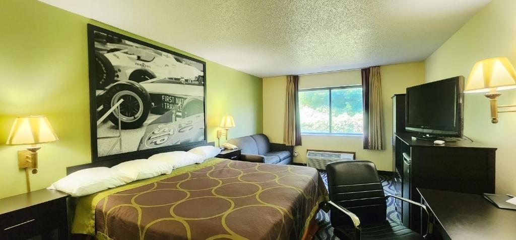 a hotel room with a bed and a flat screen tv at Super 8 by Wyndham Newton in Newton