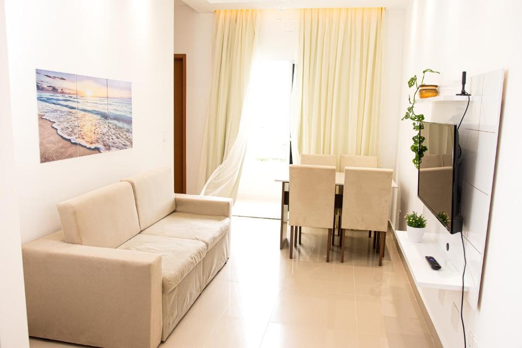 a living room with a couch and a dining room at Apartamento Aconchegante próximo à Arena Castelão in Fortaleza