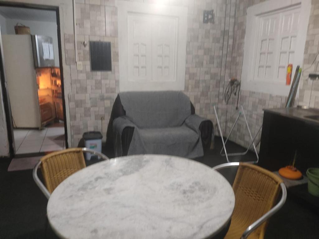 a living room with a table and a chair at Casa perto do Centro de Convenções in Recife