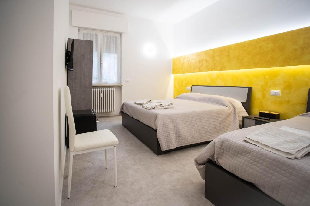 a hotel room with two beds and a chair at Residenza Ponte Catena in Verona