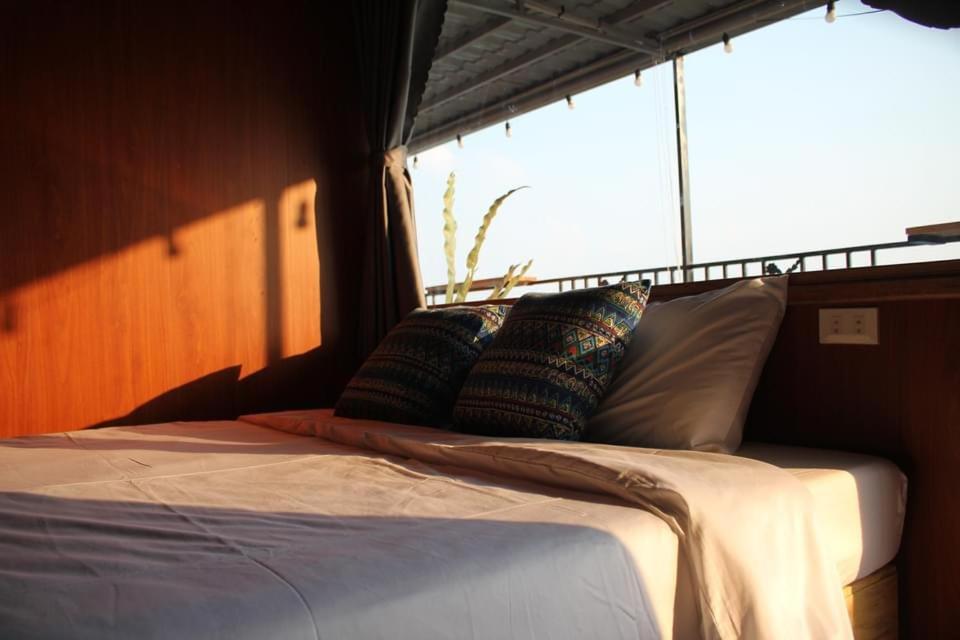 Una cama en una habitación con almohadas. en Homestay Măng Đen - ALamer, en Kon Von Kla