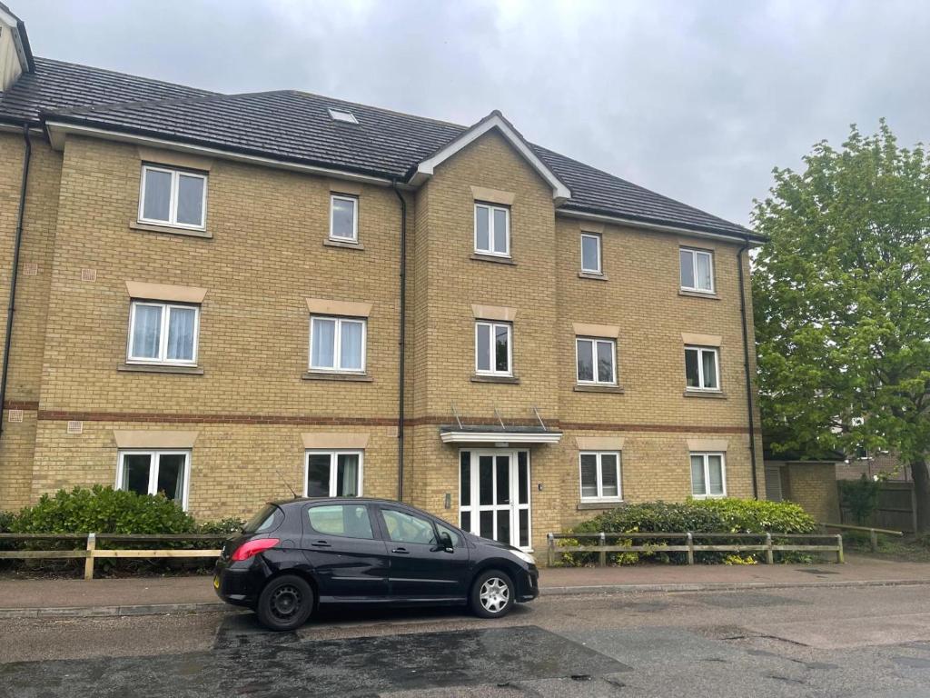 a black car parked in front of a brick house at Luxury Rooms And An En-Suite Room With Free WI-FI Clarendon Way in Colchester