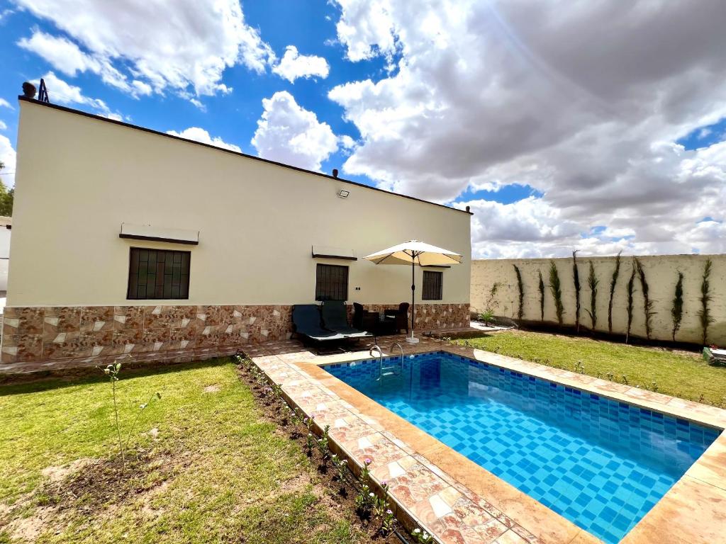 una casa con piscina accanto a un edificio di Amazing Home in Agafay area a Marrakech