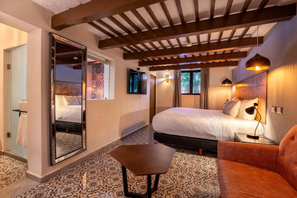 ein Hotelzimmer mit einem Bett und einem Spiegel in der Unterkunft ACQUA IN BOCCA in Mérida