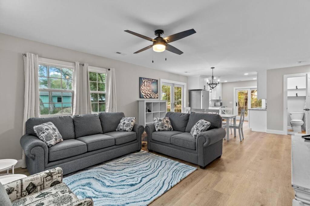 Una sala de estar con dos sofás y un ventilador de techo. en The Blue Wave Quiet & Cozy Beach Retreat, en Oak Island