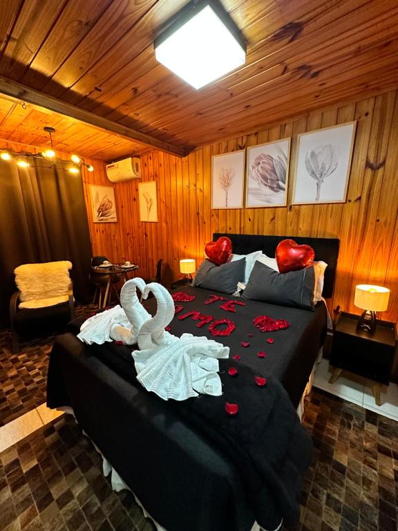 um quarto com uma cama com cisnes em Chalé Geburt em Monte Verde