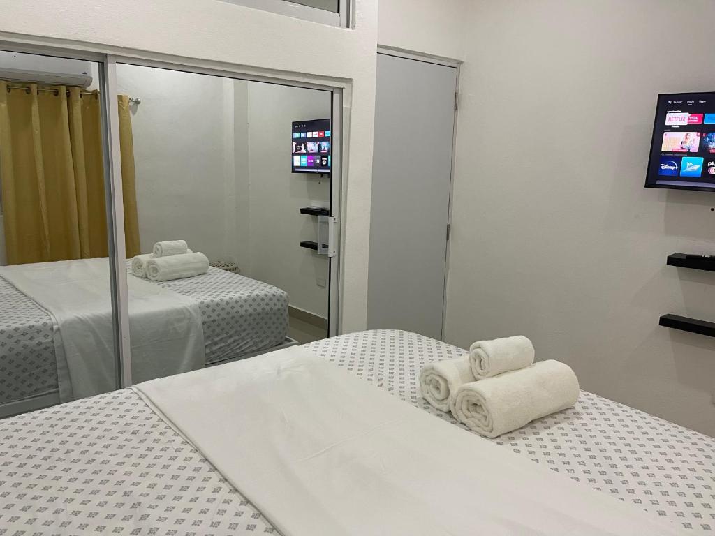 a bedroom with two beds and a mirror at Plataview Apartahotel apt 4C in Monte Plata