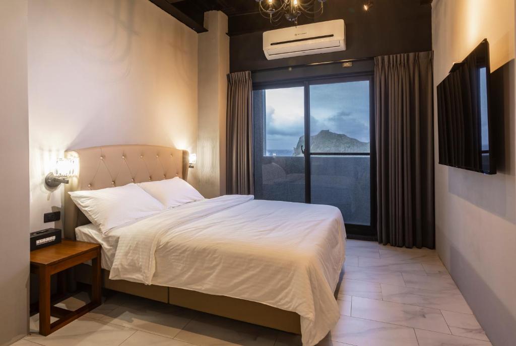 a bedroom with a bed and a large window at Chuyue Homestay in Green Island