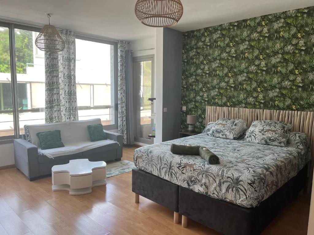 um quarto com uma cama e um sofá em Studio tropical baie des citrons em Noumea