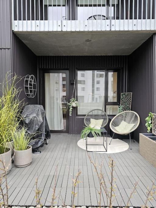 un patio con 2 sillas, mesas y plantas en The love nest in Reykjavik en Reikiavik