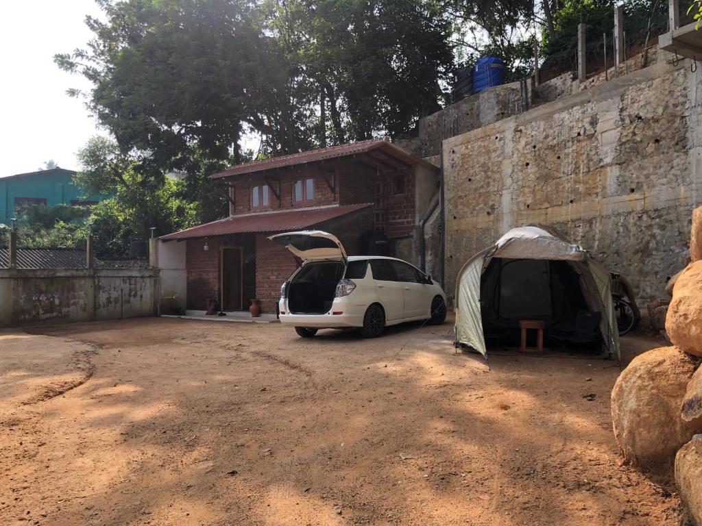 a white car parked next to a house with a tent at Bouna Vista Retreat in Galle