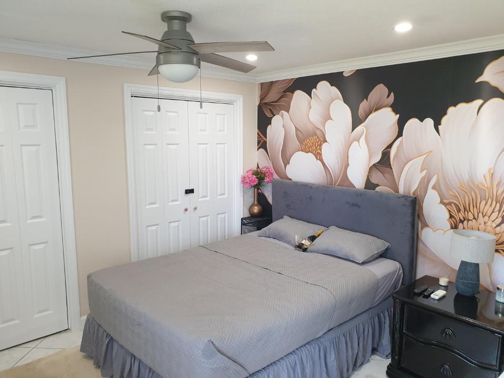 um quarto com uma cama com um mural de flores na parede em Ocean View Utopia em Cooperʼs Town