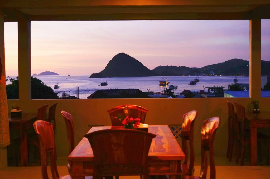 a table with chairs and a view of the ocean at Komodo Lodge in Labuan Bajo