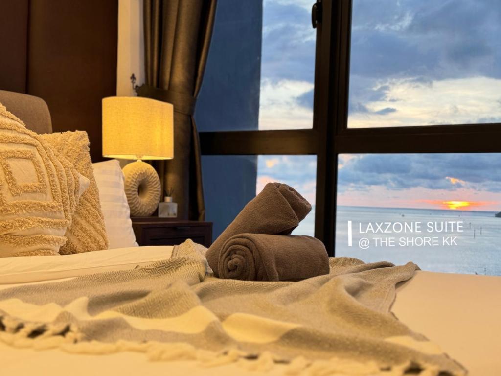 a bedroom with a bed with a view of the ocean at The Shore CBD Kota Kinabalu By LAXZONE SUITE in Kota Kinabalu